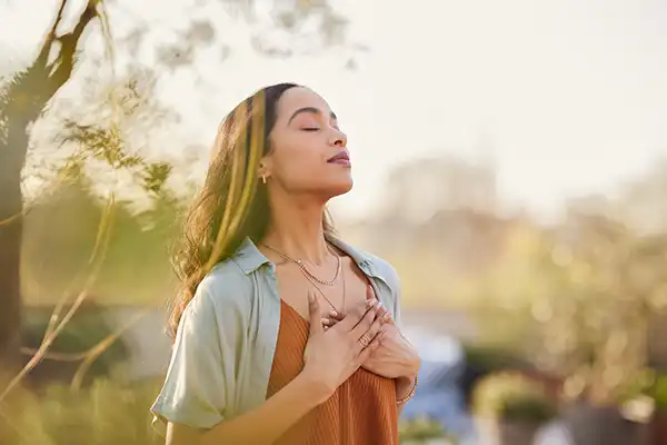 A young woman breathing and relaxing outside with her eyes closed