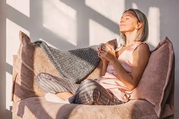 Woman sitting and relaxing with a cup of tea.