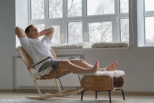 Red-headed man reclining contemplatively in a rocking chair
