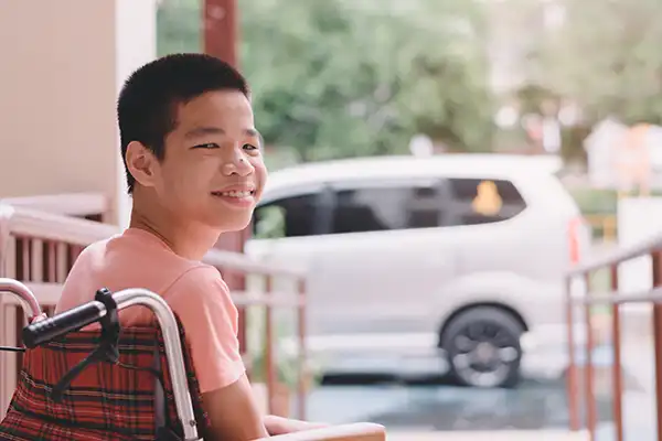 A smiling special needs child in a wheelchair
